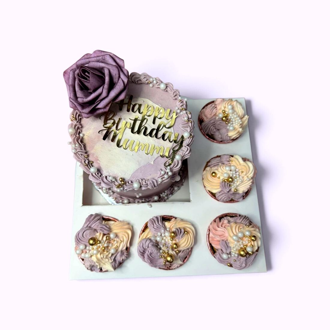 A bento cake and cupcake set finished with a sugar rose