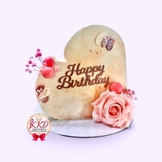 A heart shaped birthday cake with a sugar rose and pearl detail