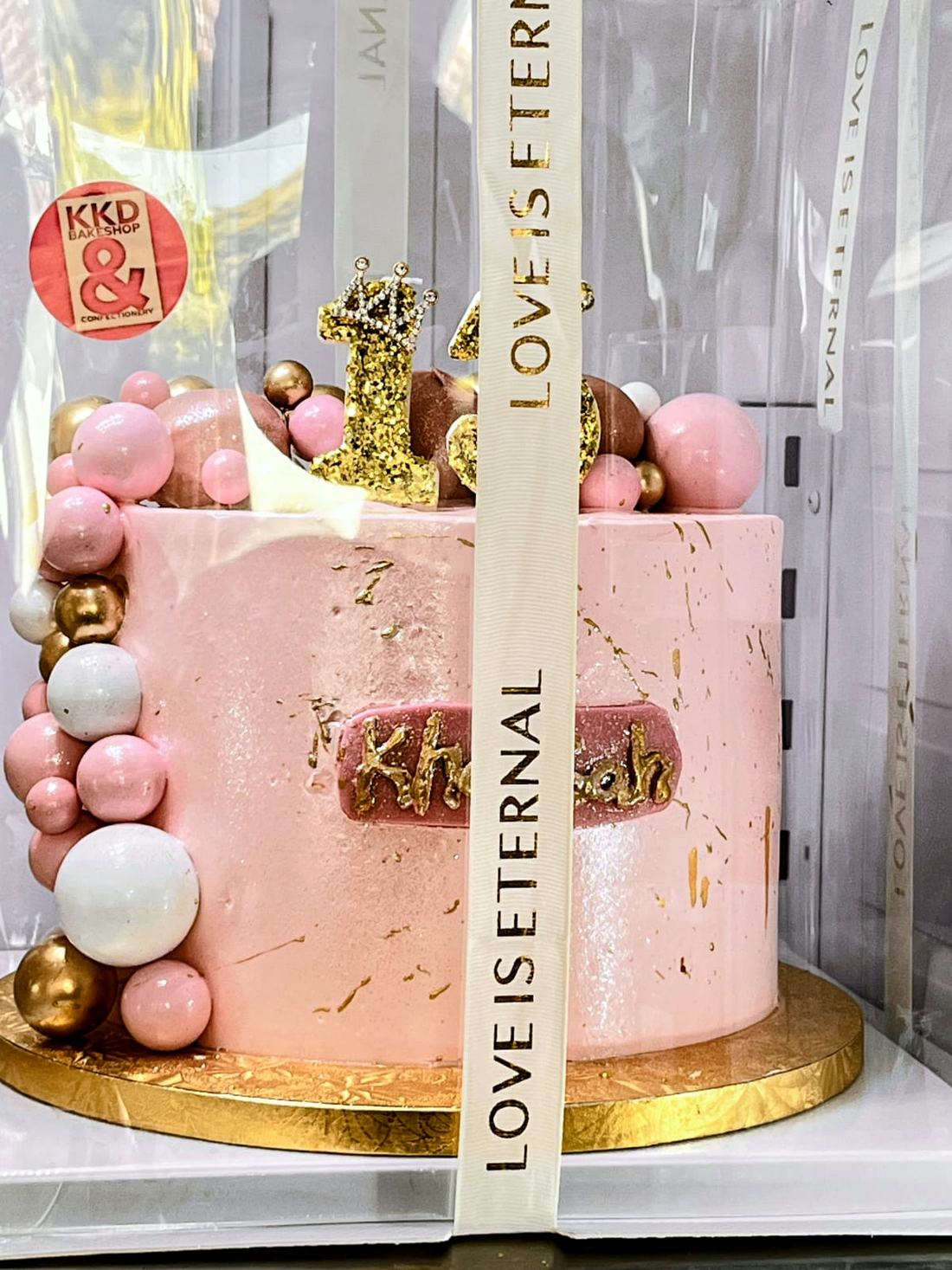 A pink and gold celebration cake made by KKD Bakeshop