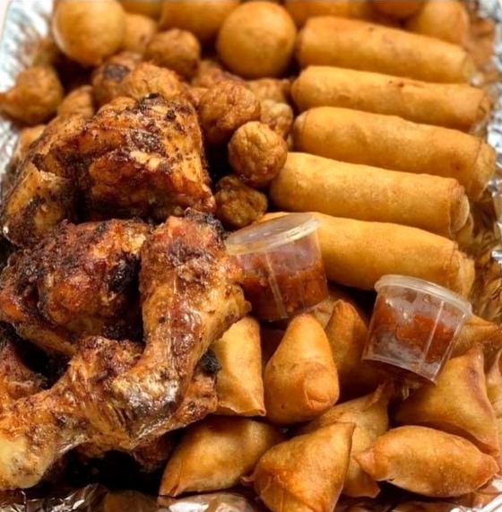 A small chops platter with peppered chicken, spring rolls and samosas